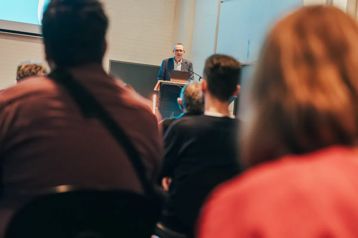 Redner spricht am Pult vor Publikum beim Mobilnetzwerktreffen 2025 in Hannover.