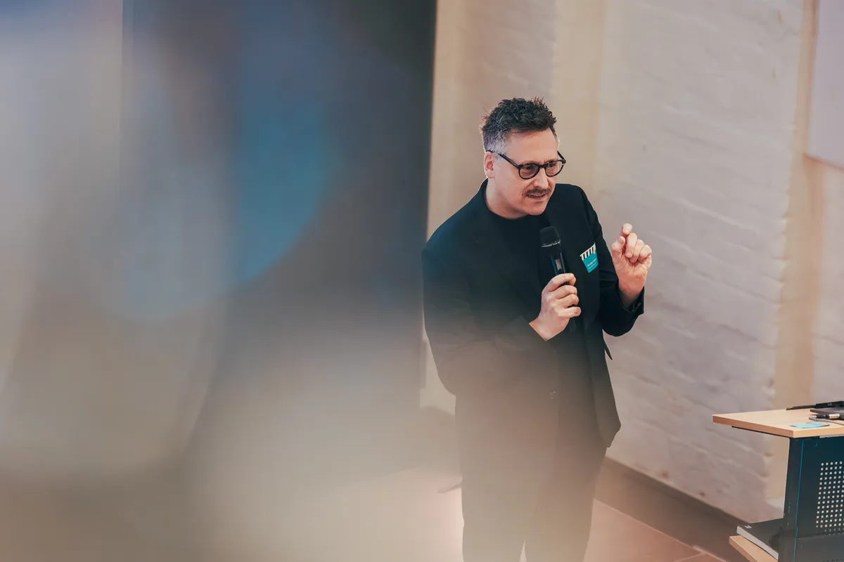 Person hält Vortrag auf Bühne vor Publikum beim Mobilnetzwerktreffen 2025 in Hannover.
