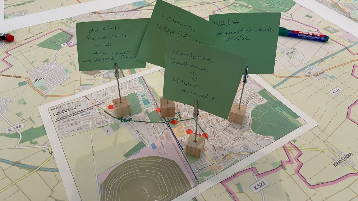 Stadtplan mit markierten Orten und grünen Karten mit handgeschriebenen Notizen aus einem Beteiligungsworkshop.